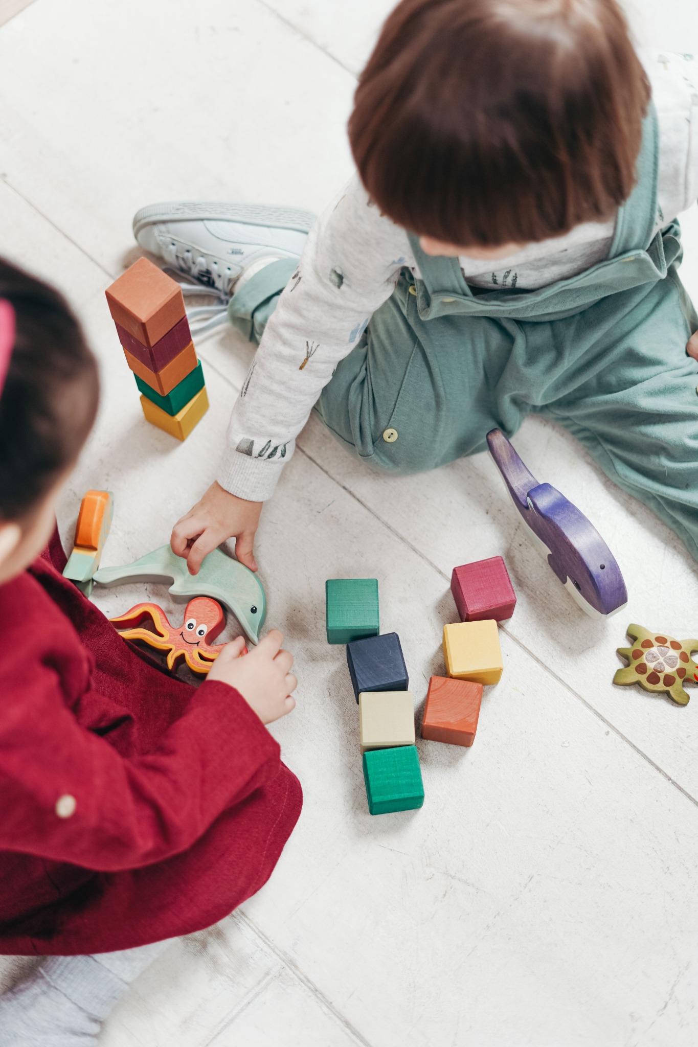 Two children playing with blocks and toys