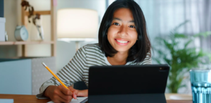 Girl sitting at desk working on speech therapy at home