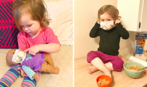 child is putting a mask on her baby doll and then sitting on the floor putting a mask on herself