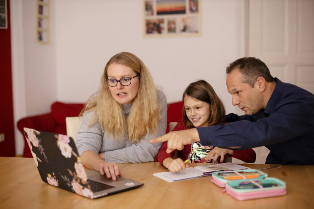 A family learning together with a laptop at home, emphasizing collaboration and education.